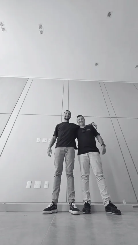 Os dois sócios da Arko juntos em um ambiente com painéis instalados.